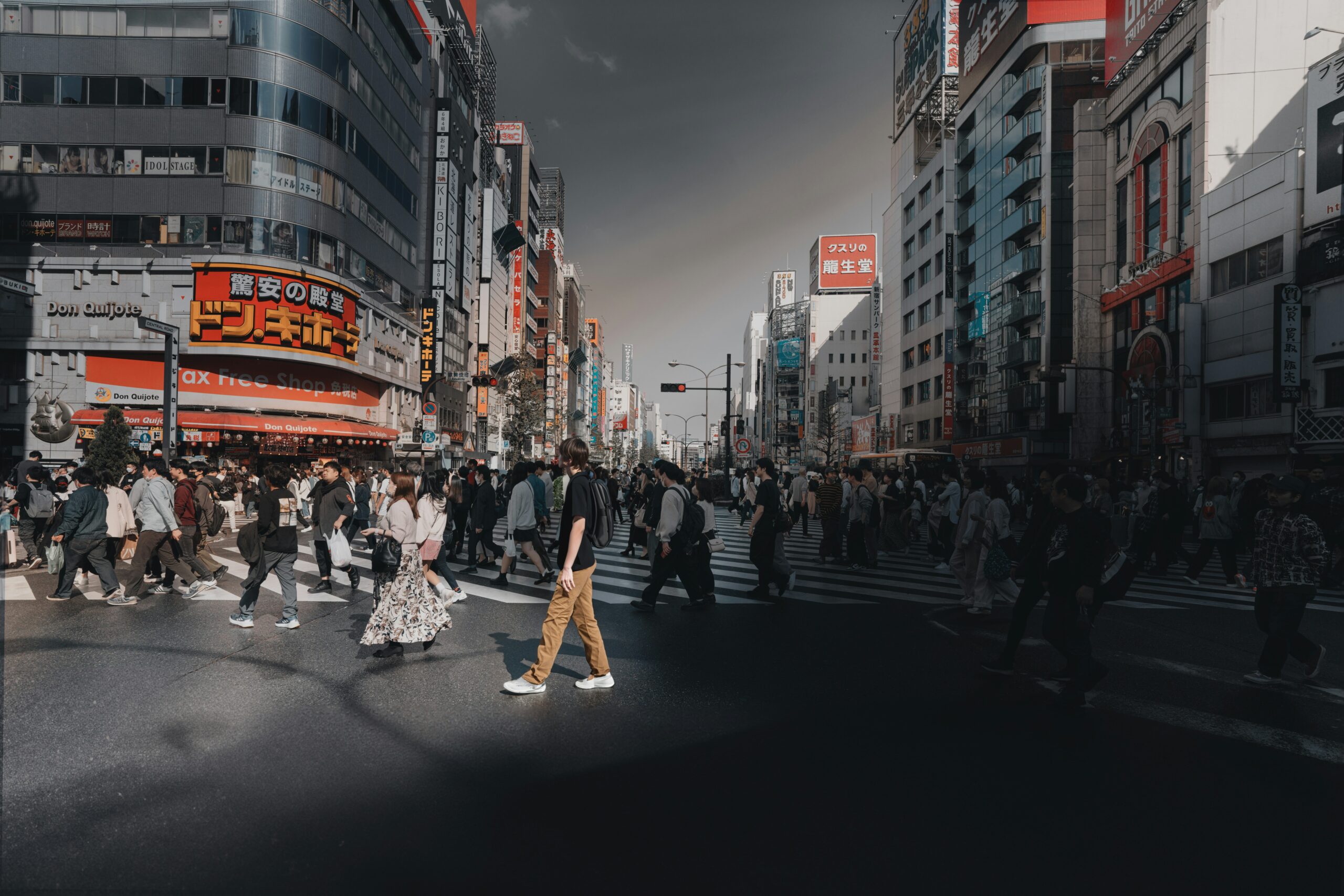 a group of people walking across a street